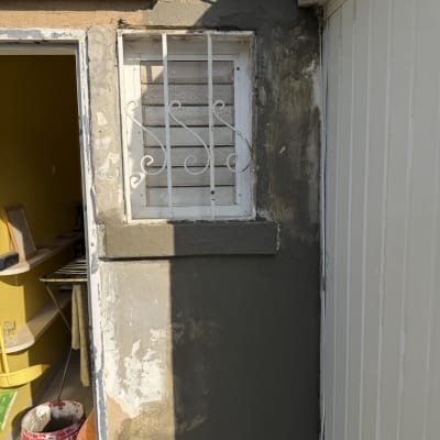 קיר עם חלון משופץ ודלי צבע