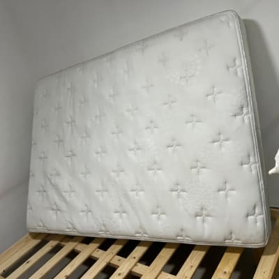 מזרן לבן עומד על מסגרת עץ