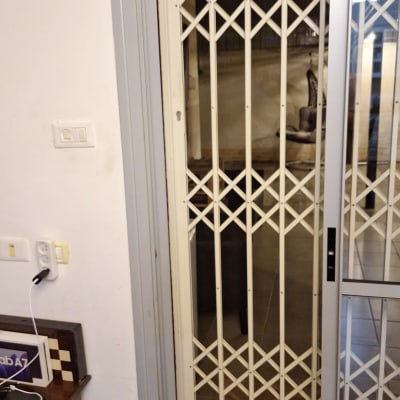 סורג מתכת מתקפל על דלת זכוכית