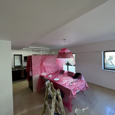 חדר עם רהיטים מכוסים בניילון ורוד לצביעת קירות