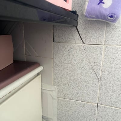 קיר עם אריחים סדוקים ותיקון עם סרט דבק