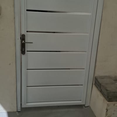 שער מתכת לבן עם ידית בצד חיצוני
