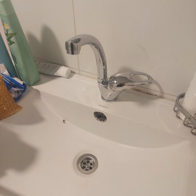 ברז כרום מותקן על כיור לבן בחדר אמבטיה