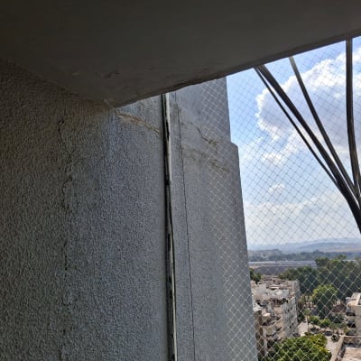 תמונה של קיר עם רשת בטיחות ונוף עירוני ברקע