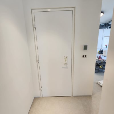 דלת לבנה מותקנת בקיר לבן עם רצפת אריחים