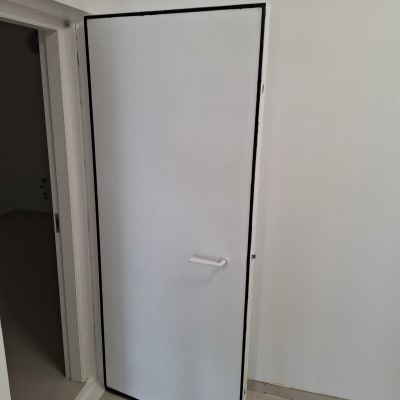 דלת לבנה עם ידית בחדר ריק