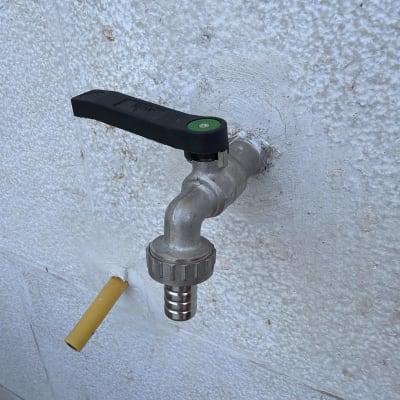 ברז מים מותקן על קיר לבן