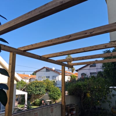 מבנה עץ בגינה עם קורות עץ ועמודים