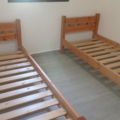 שתי מיטות עץ ללא מזרנים בחדר ריק