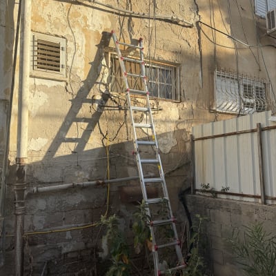 קיר חיצוני עם סולם וצינורות חשופים