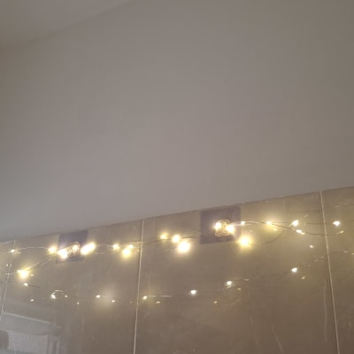 אורות קטנים תלויים על קיר עם אריחים