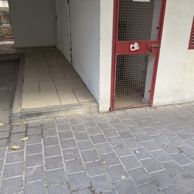 רמפה ודלת מתכת אדומה ליד קיר חיצוני