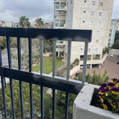 מעקה מתכת כחול עם פרחים בצד ימין