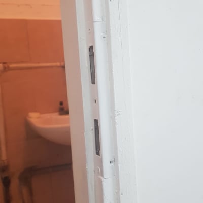 דלת לבנה עם משקוף ומנעול ללא ידית