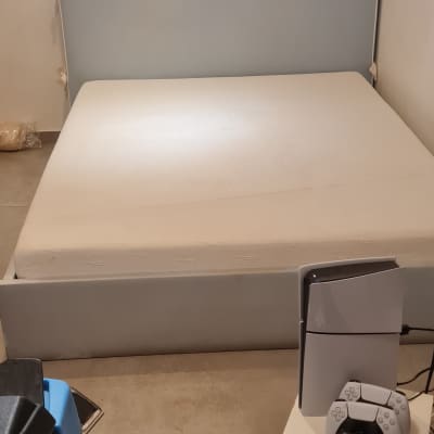 מיטה עם מזרן, שלט משחקים, מכשירים אלקטרוניים בחדר