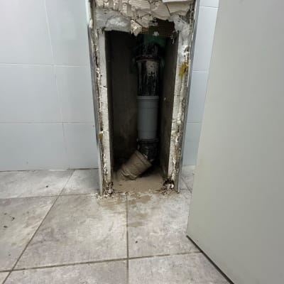 קיר פתוח עם צינור חשוף בחדר אמבטיה