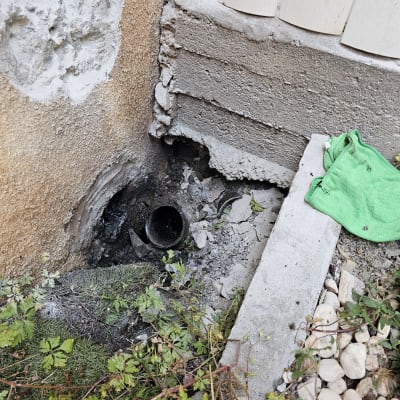 צינור ביוב חשוף ליד קיר עם בטון שבור