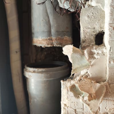 צינור מתכת חשוף בקיר עם חוטי ברזל