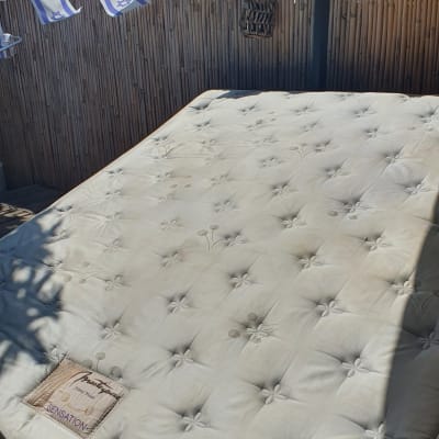 מזרן עם כתמים על משטח עץ בחוץ