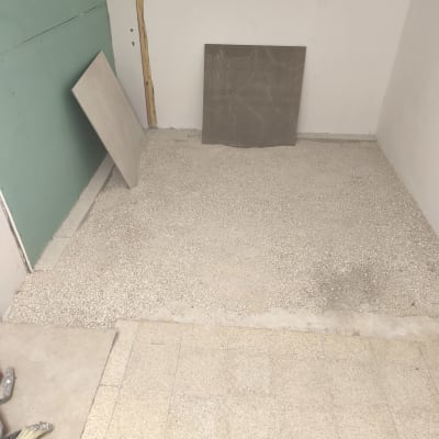 חדר עם רצפה בתהליך ריצוף ואריחים מונחים