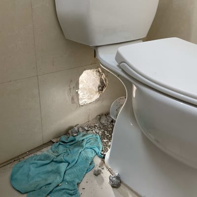 חורים בקיר ליד אסלה, מגבת על הרצפה