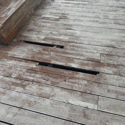 רצפת עץ עם לוחות חסרים וכתמים לבנים