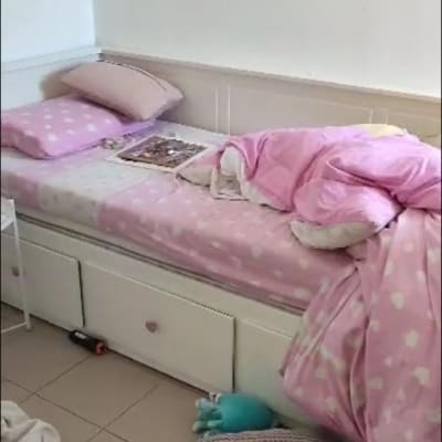 מיטה עם מצעים ורודים, כרית על הרצפה