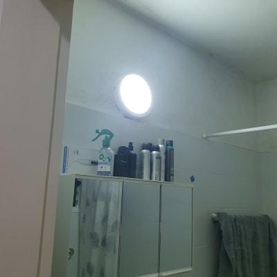 מנורה דולקת בחדר אמבטיה עם ארון מראה