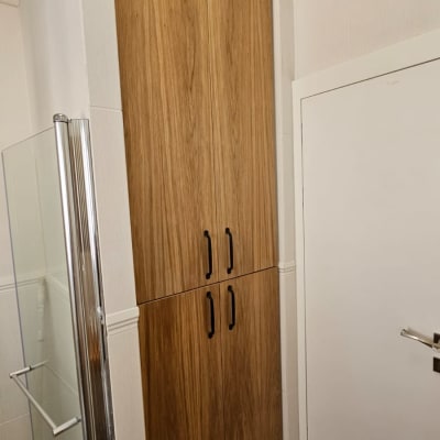 ארון עץ גבוה עם דלתות וידיות שחורות