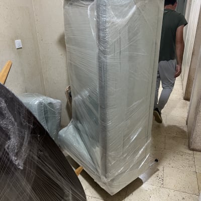 רהיטים עטופים בניילון במסדרון עם אדם הולך