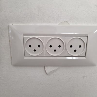 שלושה שקעים חשמליים על קיר לבן