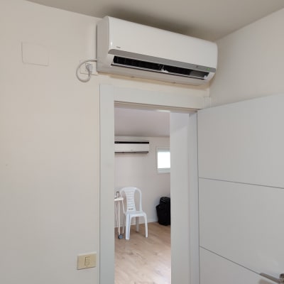 מזגן מותקן על קיר מעל דלת פתוחה