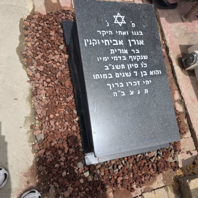מצבה שחורה עם כיתוב בעברית ואבן דוד