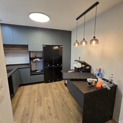 מטבח חדש עם ארונות, תאורה וכלים על השיש