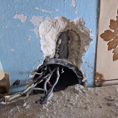 חוטי חשמל חשופים יוצאים מקיר שבור