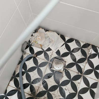 צינור גמיש על רצפת אריחים עם ניקוז