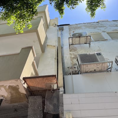בניין עם קירות מתקלפים ומזגנים מותקנים