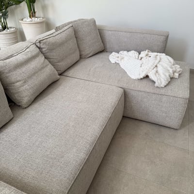 ספה אפורה עם שמיכה לבנה על מושב