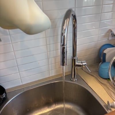 ברז נירוסטה עם מים זורמים בכיור מטבח