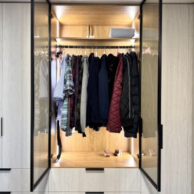 ארון בגדים פתוח עם מעילים תלויים ומדף עליון