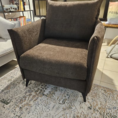 כורסה חומה על שטיח מעוצב בסלון ביתי