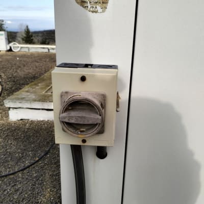 שקע חשמלי עם כבל מחובר על קיר חיצוני