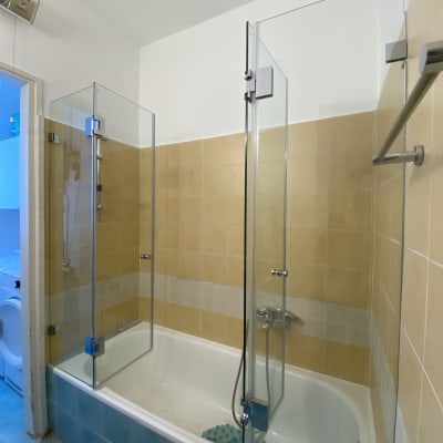 אמבטיה עם דלתות זכוכית ומקלחת יד