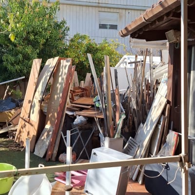 ערימת קרשים, דלתות ישנות וכלי בית בחצר