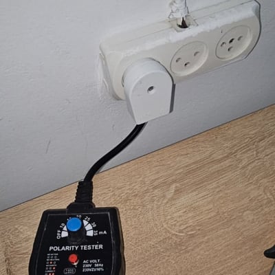 בודק פולריות מחובר לשקע חשמלי על קיר