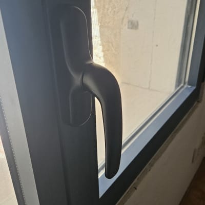 ידית חלון שחורה על מסגרת חלון