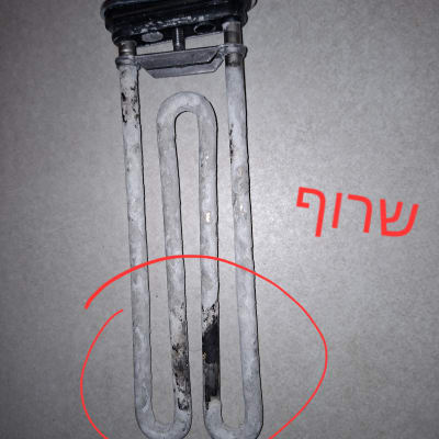 גוף חימום שרוף ומכוסה אבנית שהוחלף במהלך תיקון מכונת כביסה