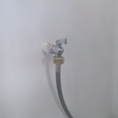 ברז מתכת עם צינור מחובר לקיר