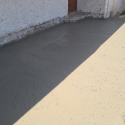 משטח בטון חדש ליד קיר חיצוני של מבנה