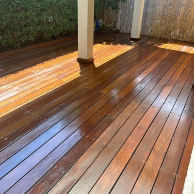 דק עץ מבריק עם עמודים וגדר במבוק